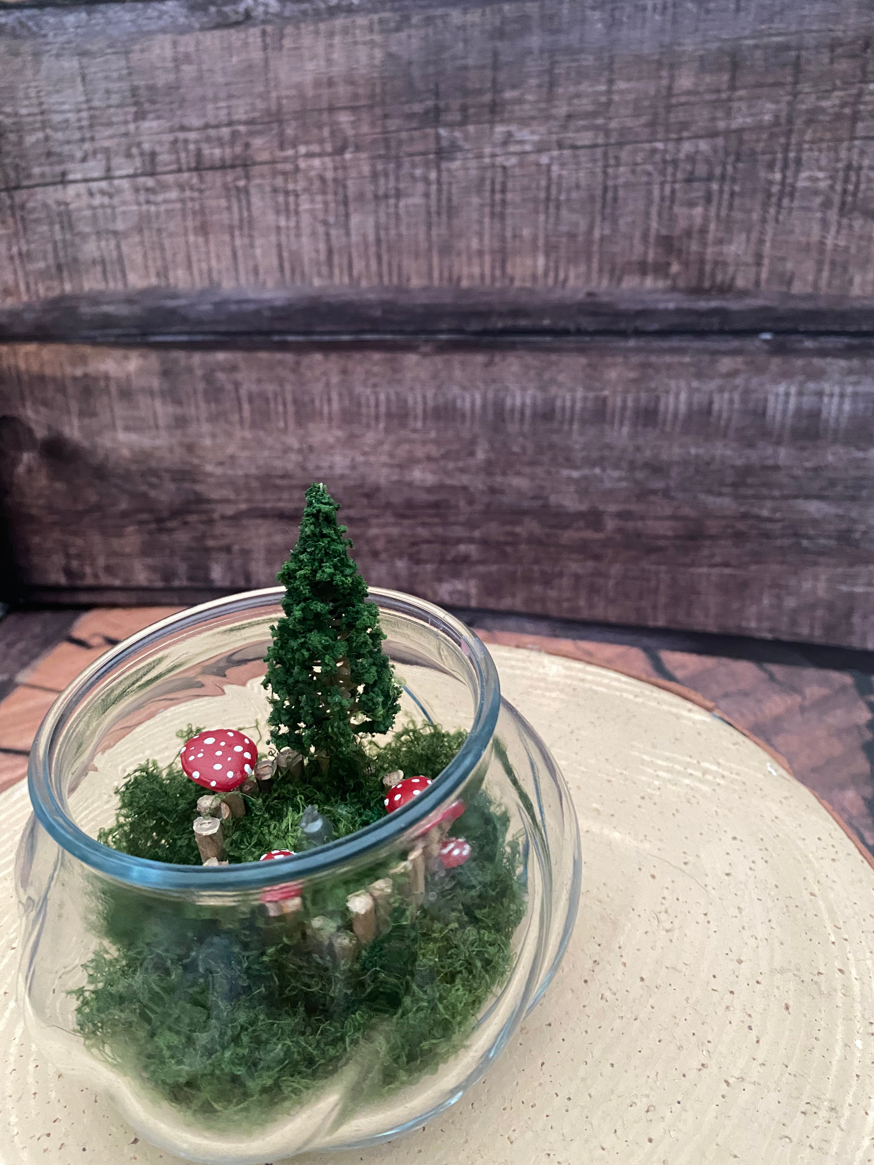 Flamless candle in mossy woodland scene in bevelled glass dish