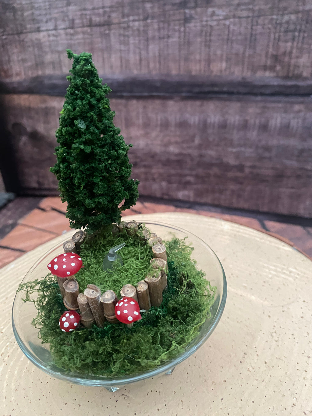 Flameless candle in small mossy campfire scene