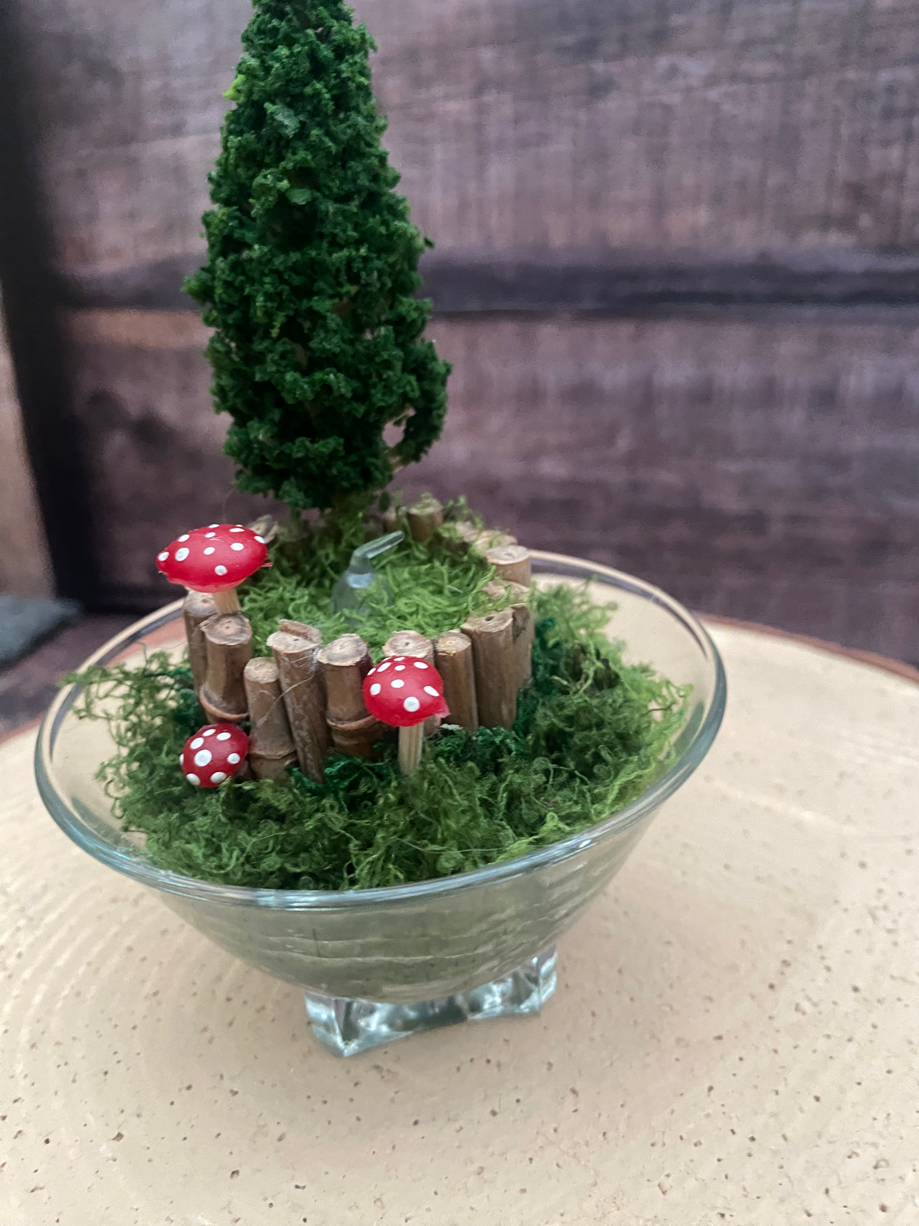 Flameless candle in small mossy campfire scene