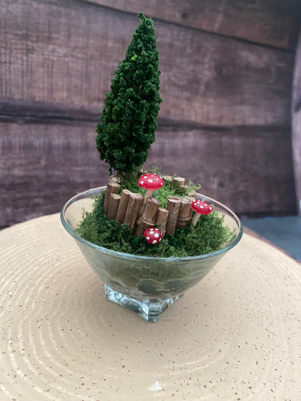 Flameless candle in small mossy campfire scene